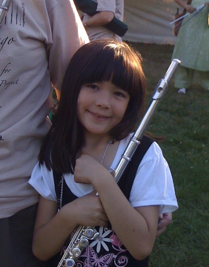 Picture of Lily Wong as a seven year old holding a flute. 